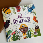 Children's book titled 'All Together' with colorful illustrations of insects and a child on a white surface.
