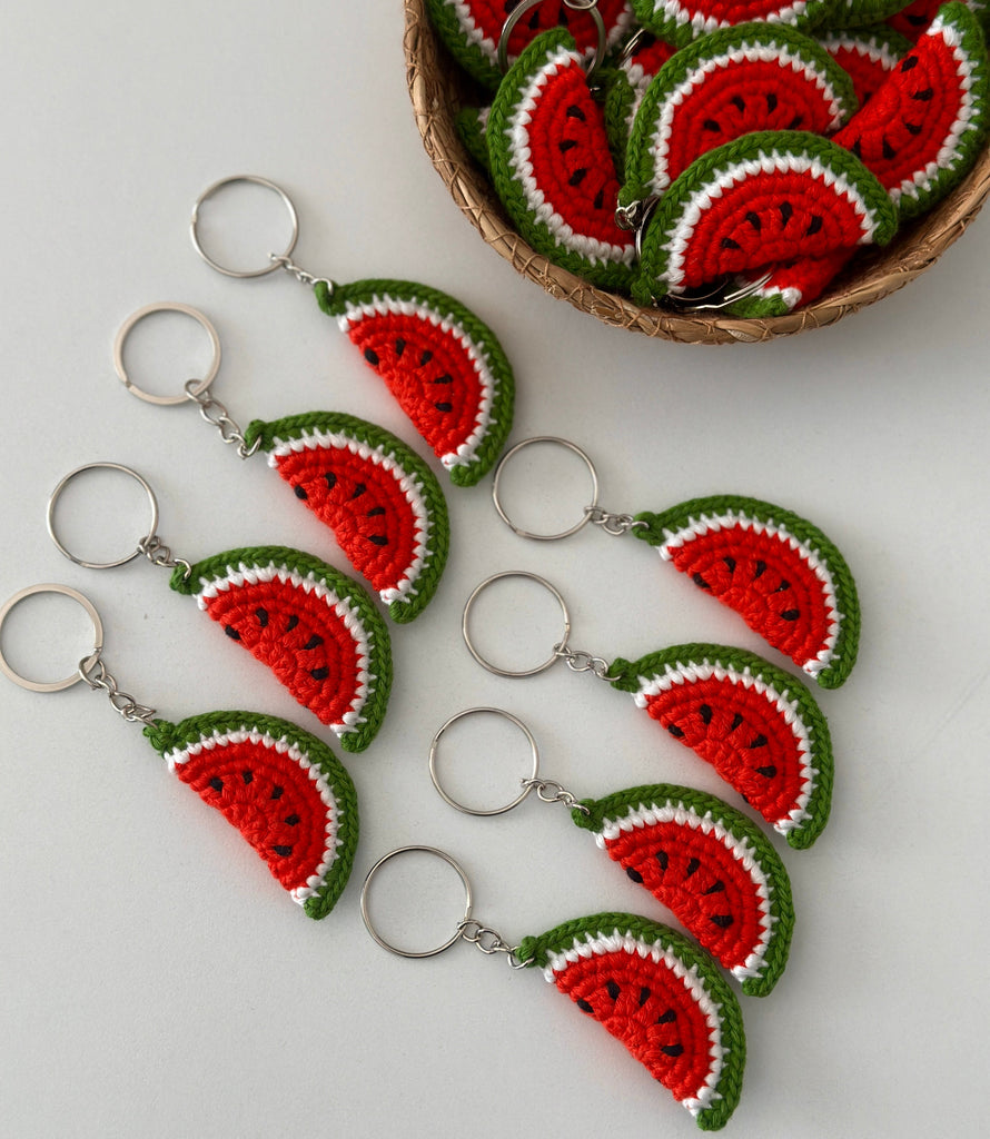 Crocheted watermelon keychains on a light gray background