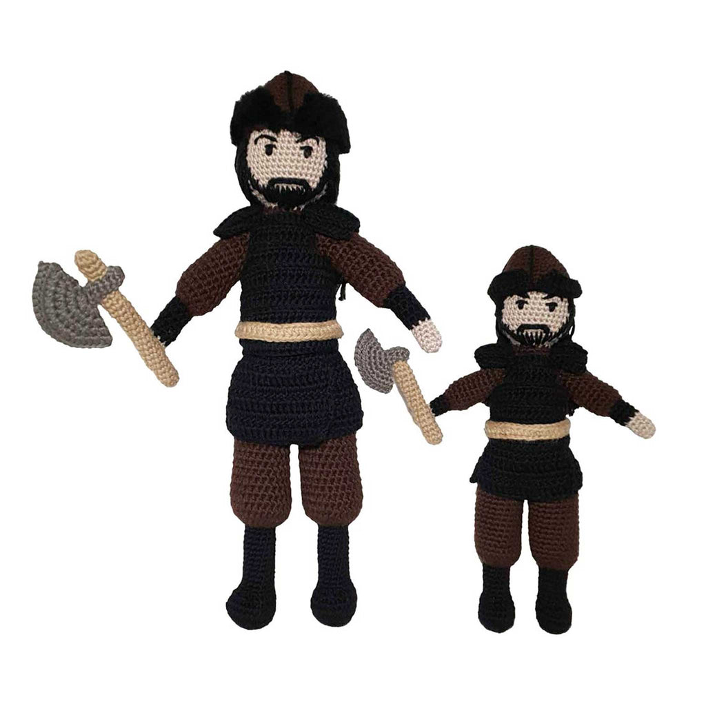 alt="Two handmade small and large Ertugrul male hero crochet dolls standing guard with long black hair and beard black and brown outfit an ottoman hat and an axe in hand"